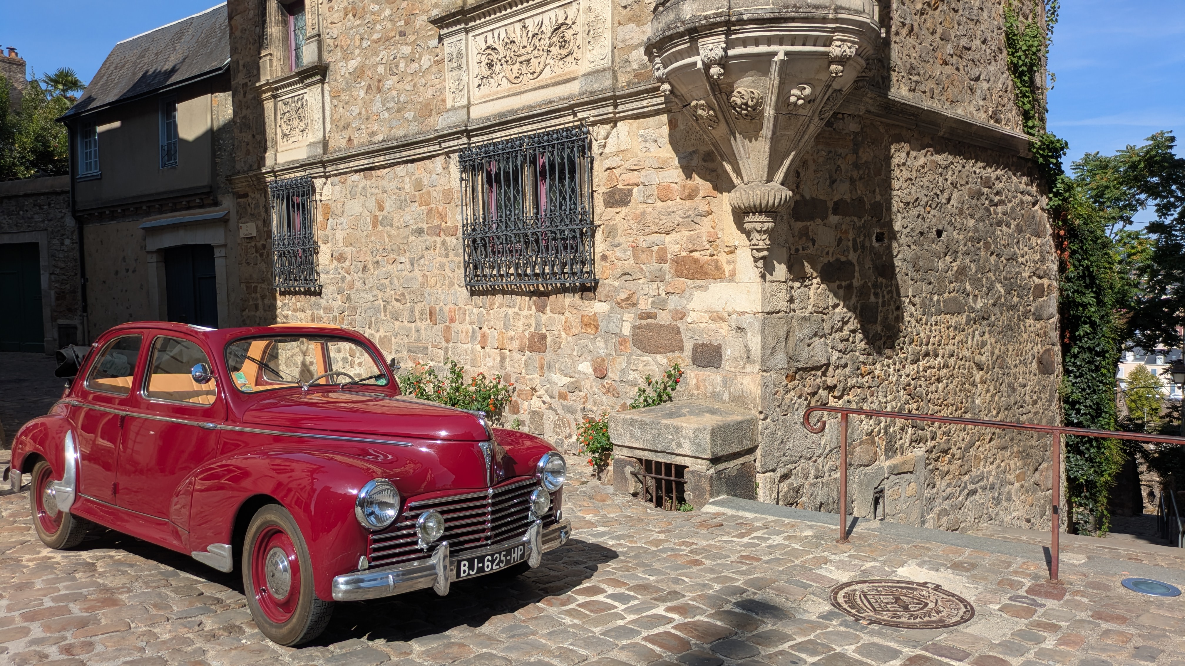 Peugeot 203 découvrable rouge dans les rues historiques du Mans